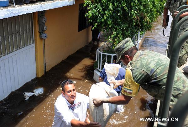 A Mexican soldier delivers a bag of sand at a flooded street in the municipality of Nezahualcoyotl, the State of Mexico, Mexico, on June 27, 2011. 
