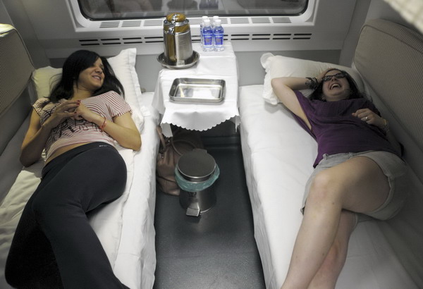 Two passengers rest in a compartment on the CRH Couchette at Shanghai railway station on June 26, 2011. To make way for the new Beijing to Shanghai bullet train, which will function from July 1st, the CRH Couchette will cease operations on June 30, according to Xinhua news agency. [Photo/Xinhua]