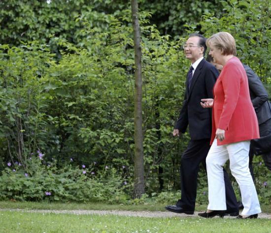 German Chancellor Angela Merkel (R) talks to Premier Wen Jiabao as they walk in the park of Villa Liebermann at the Wannsee lake before a dinner in Berlin, June 27, 2011.