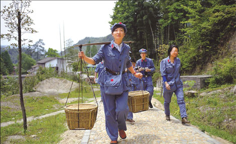 Trainees at Jinggangshan Party Members and Cadres Training Center in East China&apos;s Jiangxi province get an experience of Red Army life by carrying grain on April 29. Qian Yi / Xinhua