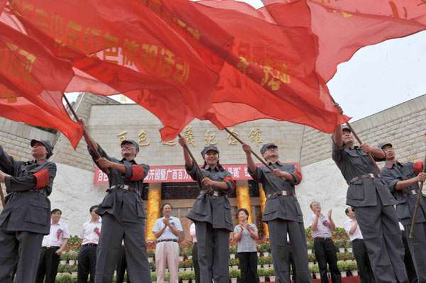 Students wave red flags in front of the Baise Revolt Memorial Hall in South China's Guangxi Zhuang autonomous region on June 28, 2011. 