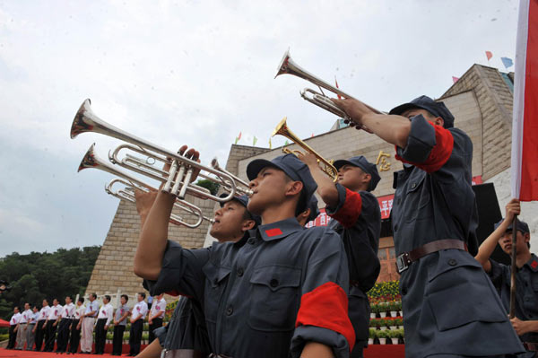 Students trumpet in front of the Baise Revolt Memorial Hall in South China's Guangxi Zhuang autonomous region on June 28, 2011.