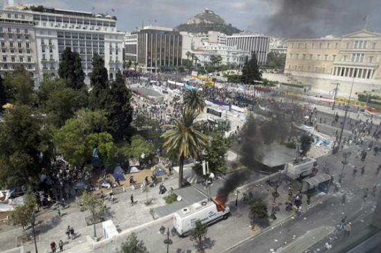 A general view of Syntagma Square shows a burning telecoms relay van in foreground during protests against austerity measures in Athens, June 28, 2011.