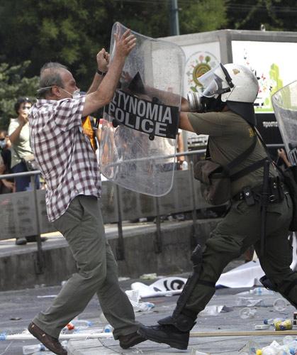 A demonstrator confronts a riot policeman during protests against austerity measures in Athens, June 28, 2011.