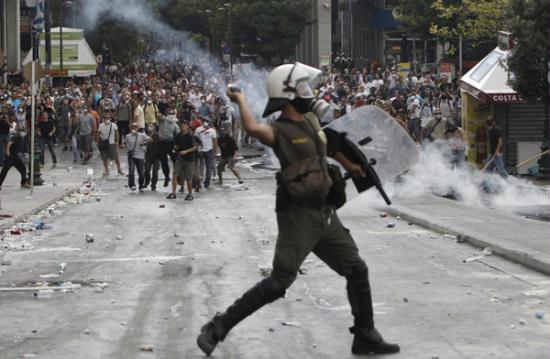 A riot policeman throws a tear gas canister at protesters during violent protests against austerity measures in Athens' Syntagma (Constitution) square, June 28, 2011.