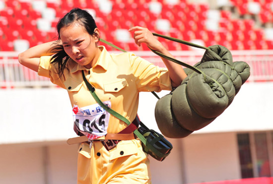 A competitor takes part in the marching-with-load event during the second national red sports meeting in Qingyang city, Northwest China's Gansu province, June 28, 2011. 