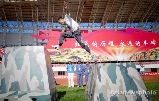 A competitor takes part in the climbing event during the second national red sports meeting in Qingyang city, Northwest China's Gansu province, June 27, 2011.