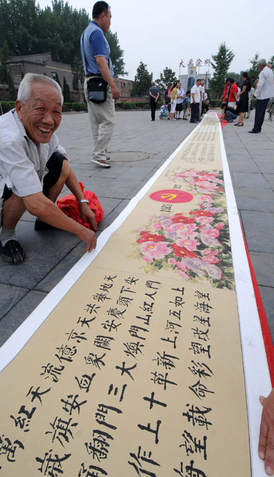 A long piece of calligraphy and painting is displayed at a square in Luoyang, Central China's Henan province, on June 27, 2011.