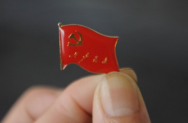 A two-centimeter-long badge of the Party flag is seen in a factory in Anqing city, East China's Anhui province, June 28, 2011.