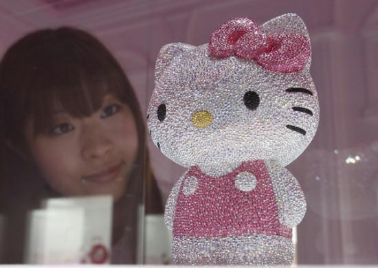 A woman looks at a Hello Kitty figurine, studded with a total of 19,636 Swarovski crystals, during a press preview of Swarovski's Hello Kitty collection at an event entitled 'House of Hello Kitty' in Tokyo on June 29, 2011. 