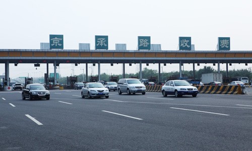 Vehicles pass the Beijing-Chengde Expressway tollgate on Thursday.