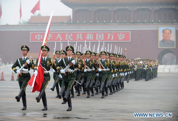 Photo taken on July 1, 2011 shows the national flag being escorted to the podium where it is raised at Tiananmen Square in Beijing, capital of China. 