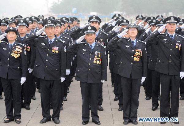 Representatives from Beijing Municipal Public Security Bureau attend the national flag-raising ceremony at Tiananmen Square in Beijing, capital of China, July 1, 2011.