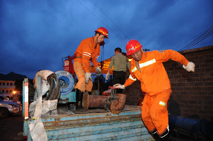 Rescuers carry pumps near the site of a coal mine accident in Pingtang of southwest China's Guizhou province, July 2, 2011. [Xinhua]