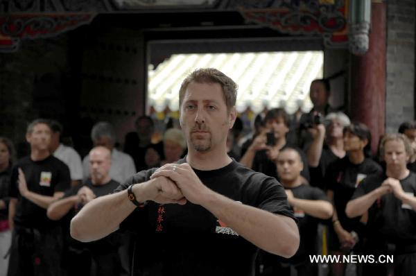 Members of United Studios of Self Defense (USSD) from the United States visit the Shaolin monks at the Shaolin Temple in Dengfeng, central China's Henan Province July 3, 2011. A group of 138 members of USSD visited the Shaolin Temple, the birthplace of modern martial arts and performed with Shaolin monks on Sunday. [Li Bo/Xinhua]