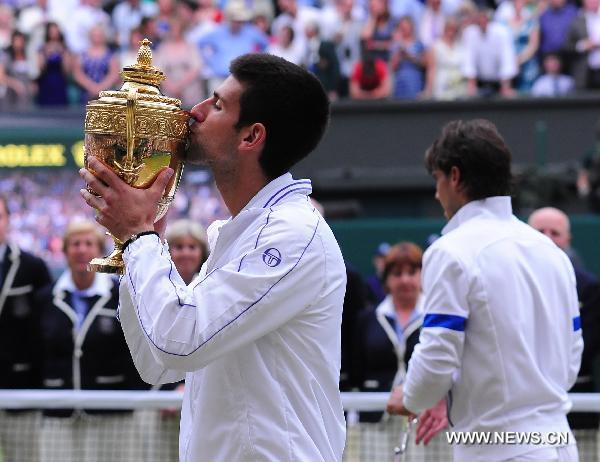 Novak Djokovic of Serbia kisses the trophy after winning the final of men's singles against Rafael Nadal of Spain in 2011 Wimbledon tennis championships in London July 3, 2011. (Xinhua/Zeng Yi) 