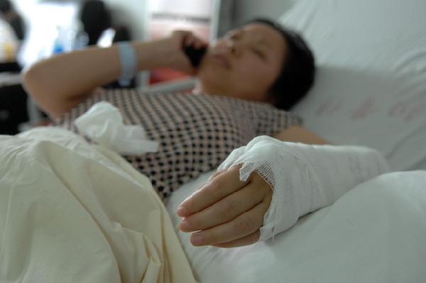Wu Juping, 31, waits for a surgery on her broken arm lying in bed in the hospital, July 3, 2011. Wu saved a two-year-old girl who fell out of the window of her 10th-floor home in East China's Zhejiang province with her arms on Saturday. [Photo/Xinhua]