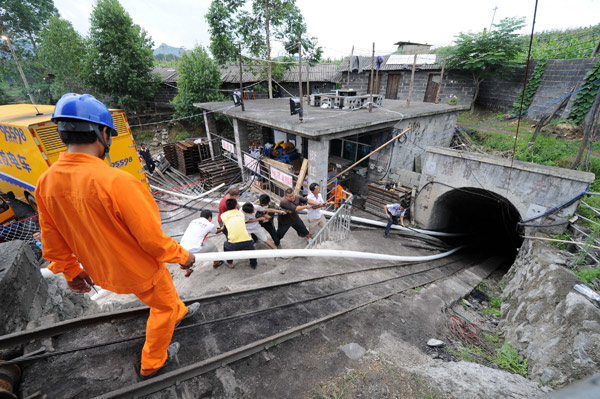 Rescuers feed cables into a mine in Guizhou province on Sunday where 23 miners were trapped on Saturday following a flood. The cables will supply electricity for rescue crews at the Niupeng Coal Mine in Pingtang county.