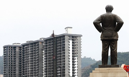 A statue of Mao Zedong overlooks new residential buildings sprouting in Yan'an of Shaanxi Province. 