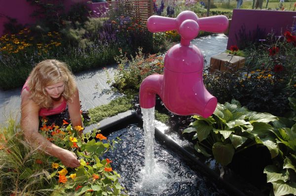 Garden designer Jill Foxley poses for a photograph next to a suspended tap on press day at the Hampton Court Palace Flower Show at Kingston-upon-Thames in south west London Garden designer Jill Foxley poses for a photograph next to a suspended tap on press day at the Hampton Court Palace Flower Show at Kingston-upon-Thames in south west London July 4, 2011. (Xinhua/Reuters)