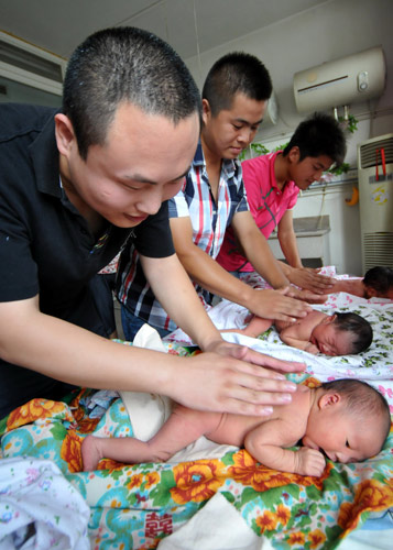 Fathers learn how to massage their babies in Xingtai, Hebei province. In the Chinese mainland, mothers are increasingly forced to shoulder the lion's share of parenting. 