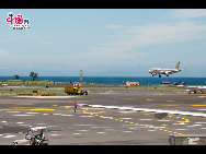 An Asiana passenger jet making its landing at Jeju International Airport forgrounded by the azure sea that has cleared up from the recent mist. [François Chen / China.org.cn]