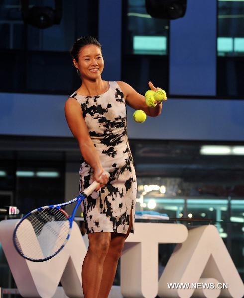 Li Na of China, the first Asian to win a Grand Slam title at the French Open, presents balls to her fans at a celebration organized by the Women's Tennis Association (WTA) at Sanlitun SOHO in Beijing, China, July 5, 2011. (Xinhua/Gong Lei)