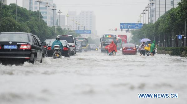 Vehicles run on a waterlogged street in Yangzhou, east China&apos;s Jiangsu Province, July 5, 2011. A heavy rainfall caused the flood in Yangzhou on Tuesday. [Xinhua]