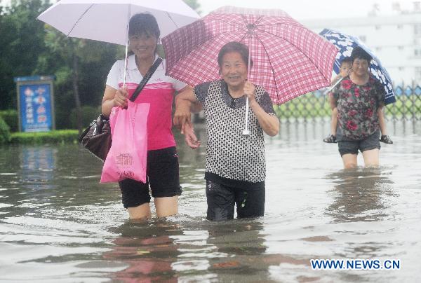 Pedestrians walk on a waterlogged street in Yangzhou, east China&apos;s Jiangsu Province, July 5, 2011. A heavy rainfall caused the flood in Yangzhou on Tuesday.