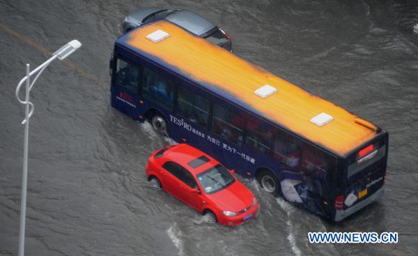 Vehicles run on a waterlogged street in Yangzhou, east China&apos;s Jiangsu Province, July 5, 2011. A heavy rainfall caused the flood in Yangzhou on Tuesday.