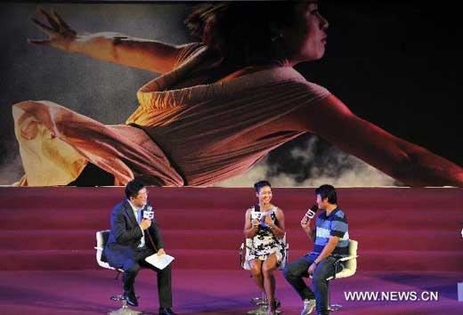 Li Na (C) of China, the first Asian to win a Grand Slam title at the French Open, is interviewed by reporters before a celebration organized by the Women’s Tennis Association (WTA) at Sanlitun SOHO in Beijing, China, July 5, 2011. [Xinhua]