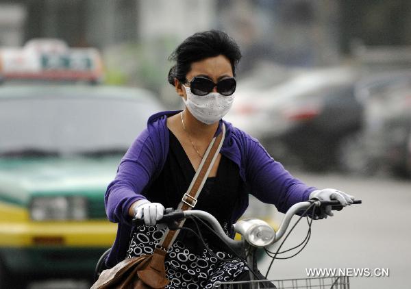 A citizen rides on a dusty day in Yinchuan, northwest China&apos;s Ningxia Hui Autonomous Region, July 6, 2011. The city was hit by a sandy weather Wednesday.