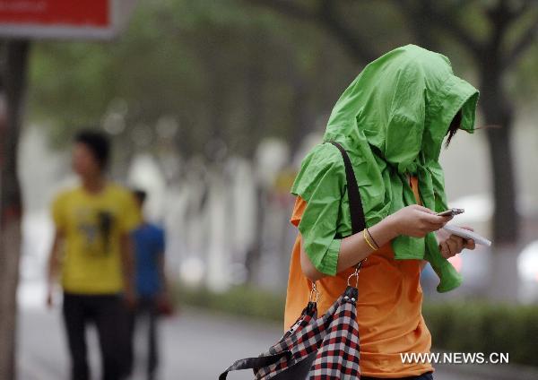 A citizen walks on a dusty day in Yinchuan, northwest China&apos;s Ningxia Hui Autonomous Region, July 6, 2011. The city was hit by a sandy weather Wednesday.