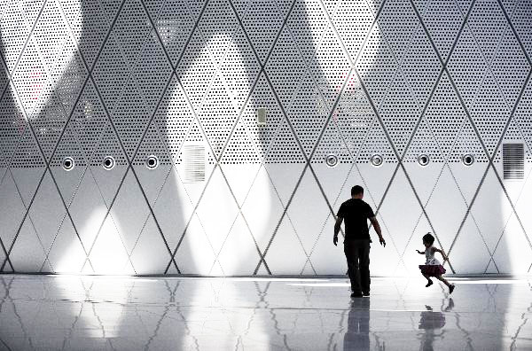 A man with his child walked on the square inside the Shenzhen Bay Sports Center, also known as Spring Cocoon, in Shenzhen, south China's Guangdong Province, June 15, 2011. [Photo/Xinhua] 