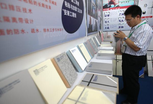 A visitor views a sample of low-carbon construction material at China International Low-carbon Industry Exhibition, opened in Beijing, capital of China, July 7, 2011. [Xinhua] 