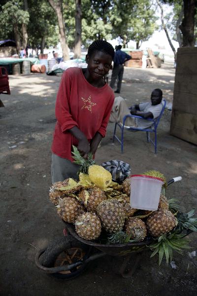  A girl buys pineapple in the southern Sudanese city of Juba, July 8, 2011. Sudanese government on Friday officially announced its recognition of South Sudan as an independent state with sovereignty as of Saturday based on the borderline of Jan. 1, 1956. (Xinhua/Nasser Nouri)