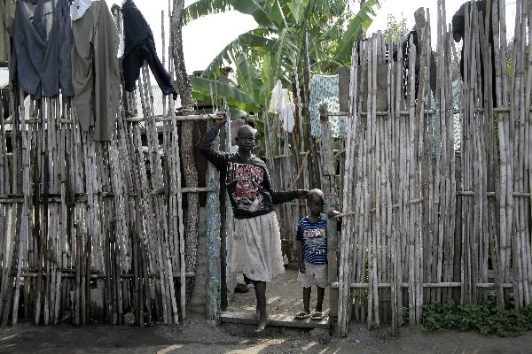 A girl with her relative stands outside their home in the southern Sudanese city of Juba, July 8, 2011. Sudanese government on Friday officially announced its recognition of South Sudan as an independent state with sovereignty as of Saturday based on the borderline of Jan. 1, 1956. (Xinhua/Nasser Nouri) 