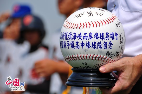 Pingzhen High School baseball team receive the extra-sized baseball as a souvenir from High School Affiliated to Beijing Normal University shortly before the opening match of the tournament. [Pierre Chen / China.org.cn]