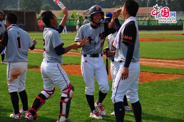 Players from Pingzhen cheers as their No. 19 player makes a home run. [Pierre Chen / China.org.cn]