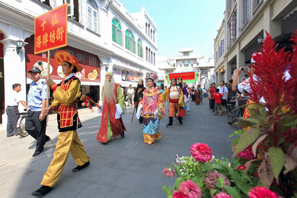 Performers of Chaozhou opera dressed in colorful costumes parade the Gateway Street in Chaozhou city. 