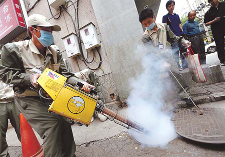Workers try to kill cockroaches in a sewer at Dengshikou Dajie, Dongcheng district. New statistics show that the number of pests in the city fell but rats increased in the past year. [China Daily] 