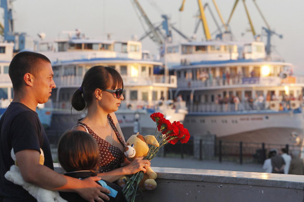 A family brings flowers in memory of victims of the tourist boat 'Bulgaria', which sank on the Volga river, at the port of Kazan July 11, 2011.