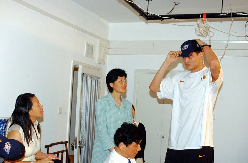 Yao Ming put on a Rockets' hat after selected by Houston Rockets as the first overall pick in the 2002 NBA Draft.