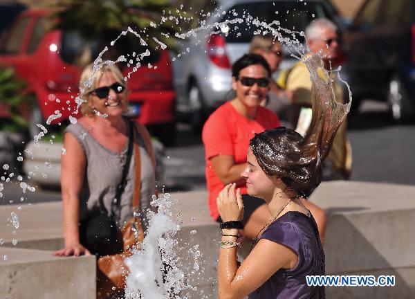 A girl cools off in a fountain in downtown Rome, capital of Italy, July 12, 2011. This year&apos;s first heatwave hit Italy recently, which stretched 13 cities including Rome to red alerts on Tuesday.