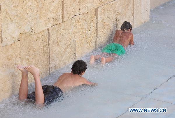 Children cool off in a fountain in downtown Rome, capital of Italy, July 12, 2011. This year&apos;s first heatwave hit Italy recently, which stretched 13 cities including Rome to red alerts on Tuesday. 