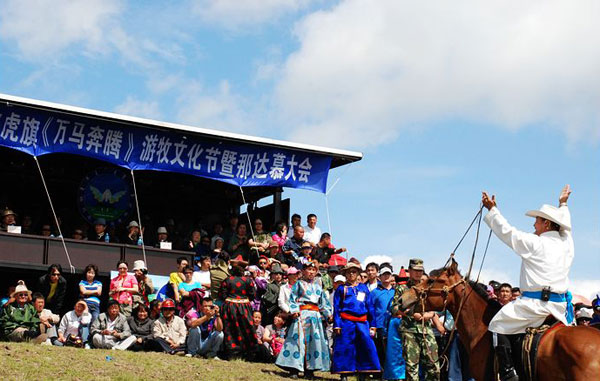 People dressed in festive costumes attend the opening ceremony of the Nadam Fair, the most important celebration for the Mongolian ethnic minority of China's Inner Mongolia Autonomous Region. The fair opened in the city of Hulun Buir on Tuesday, July 12. The one and half day fair will feature traditional Mongolian sporting competitions such as horse races, archery and wrestling. [Photo:CRIENGLISH.com] 