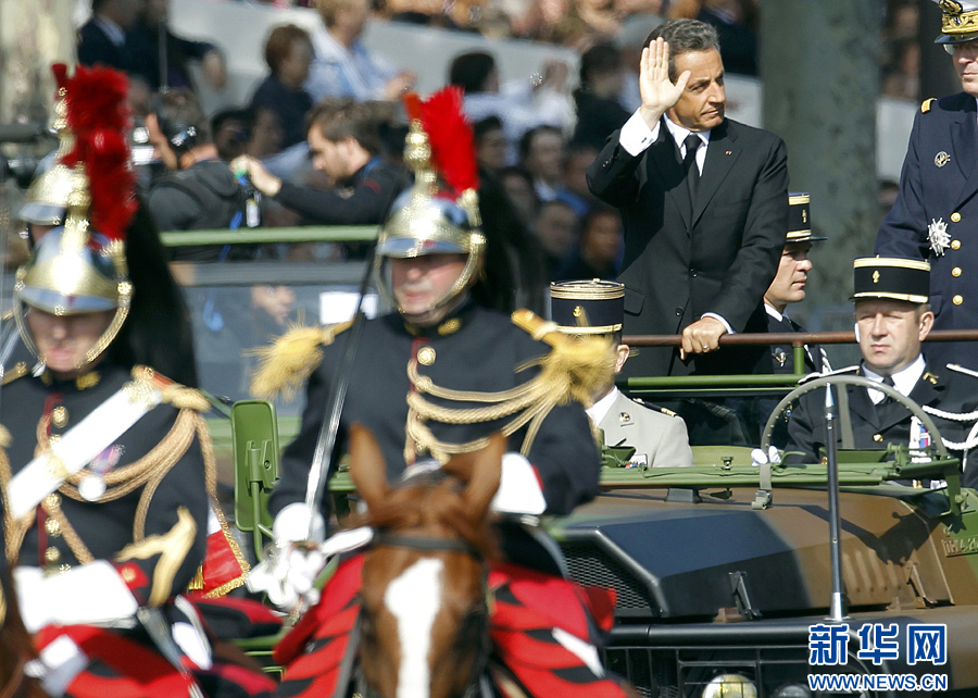 France's President Sarkozy waves as he rides down the Champs Elysee during the traditional Bastille Day parade in Paris, July 14, 2011. [Xinhua]