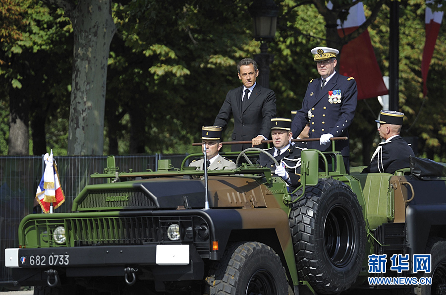 France's President Sarkozy waves as he rides down the Champs Elysee during the traditional Bastille Day parade in Paris, July 14, 2011. [Xinhua]