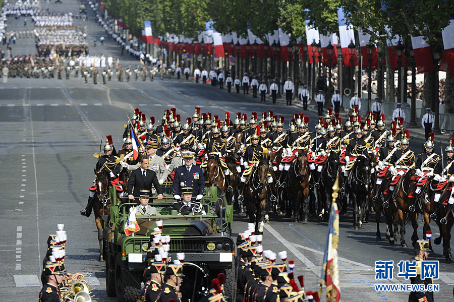 A military vehicle carrying France's president Nicolas Sarkozy (L) and Chief of the French defence staff, Admiral Edouard Guillaud drives down the Champ-Elysees during the annual Bastille Day military parade in Paris, on July 14, 2011.