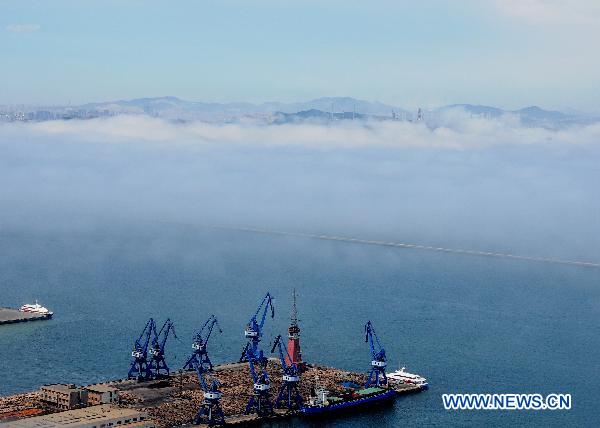 Photo taken on July 14, 2011 shows the advection fog surrounding buildings in the Donggang harbor in Dalian City, northeast China&apos;s Liaoning Province. 